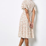 Woman wearing a floral dress with a plain background