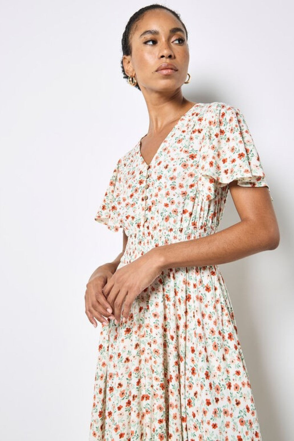 Woman wearing a floral dress against a plain background