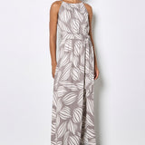 Woman wearing a long leaf-patterned dress against a white background