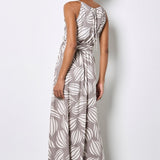 Woman wearing a gray and white leaf-patterned dress against a plain background