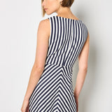 Woman wearing a black and white striped dress against a plain background