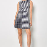 Woman wearing a black and white striped dress against a plain background
