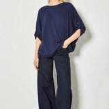 Woman wearing a navy blue outfit with wide-leg pants against a white background