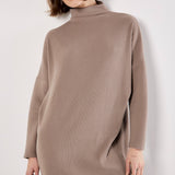 Woman wearing a brown ribbed knit dress against a white background