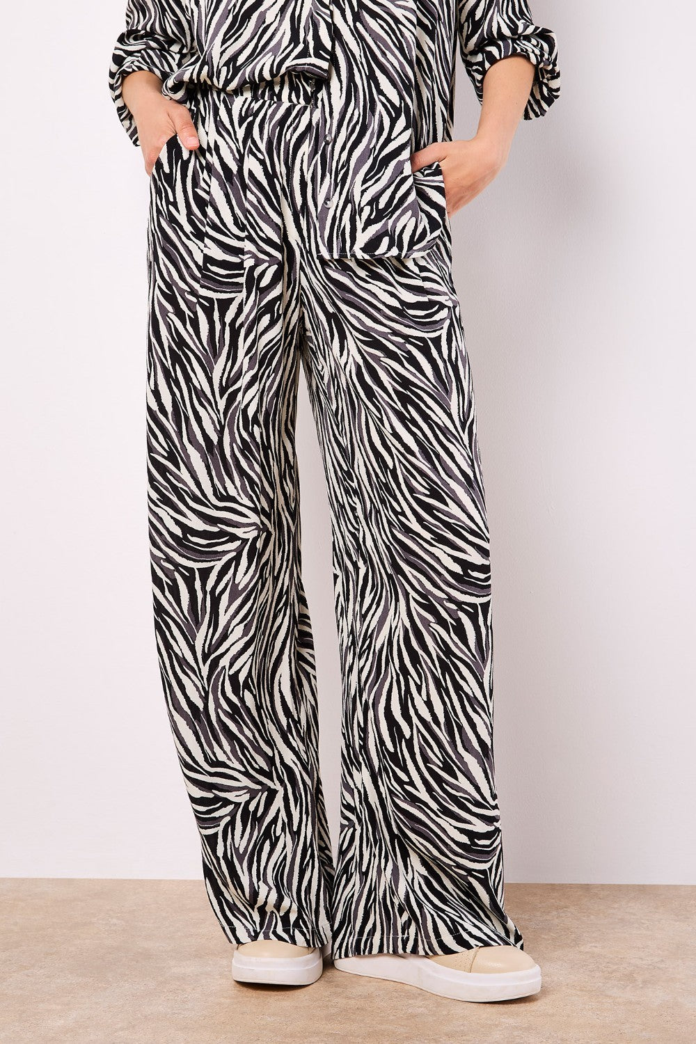 Lightweight, woven and textured, these wide-leg trousers are designed to create a fluid silhouette. Boasting a bold zebra print, they feature an elastic panel at the waist for a comfortable fit, a hook and zip fastening, plus practical pockets.