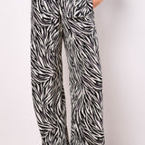 Lightweight, woven and textured, these wide-leg trousers are designed to create a fluid silhouette. Boasting a bold zebra print, they feature an elastic panel at the waist for a comfortable fit, a hook and zip fastening, plus practical pockets.
