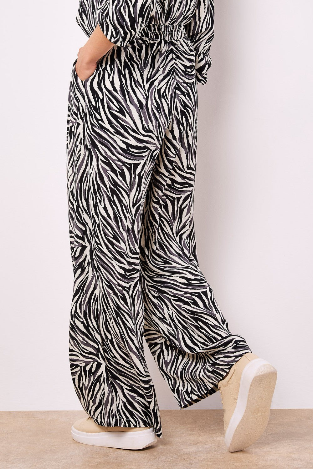 Lightweight, woven and textured, these wide-leg trousers are designed to create a fluid silhouette. Boasting a bold zebra print, they feature an elastic panel at the waist for a comfortable fit, a hook and zip fastening, plus practical pockets.