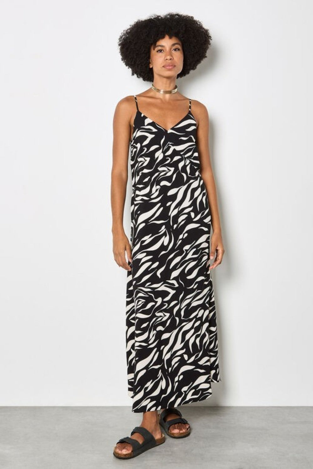 Woman wearing a black and white patterned dress against a plain background