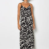 Woman wearing a black and white patterned dress against a plain background