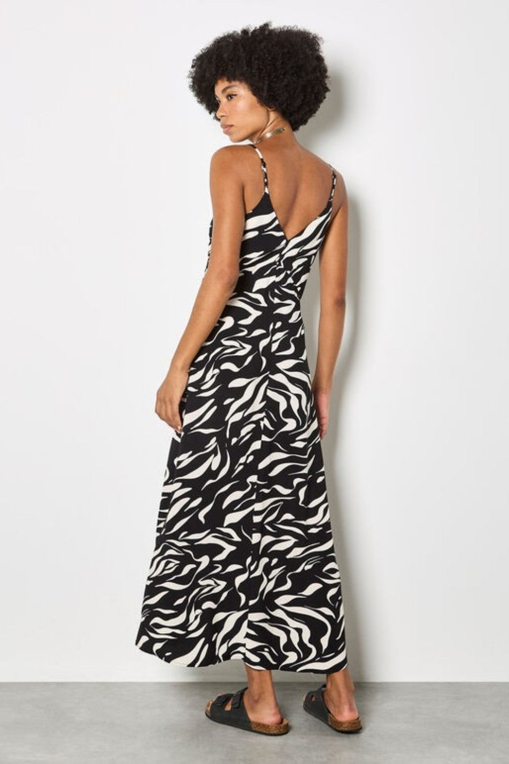 Woman wearing a zebra print dress against a white background