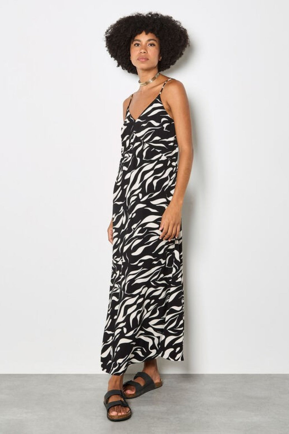 Woman wearing a zebra print dress against a white background