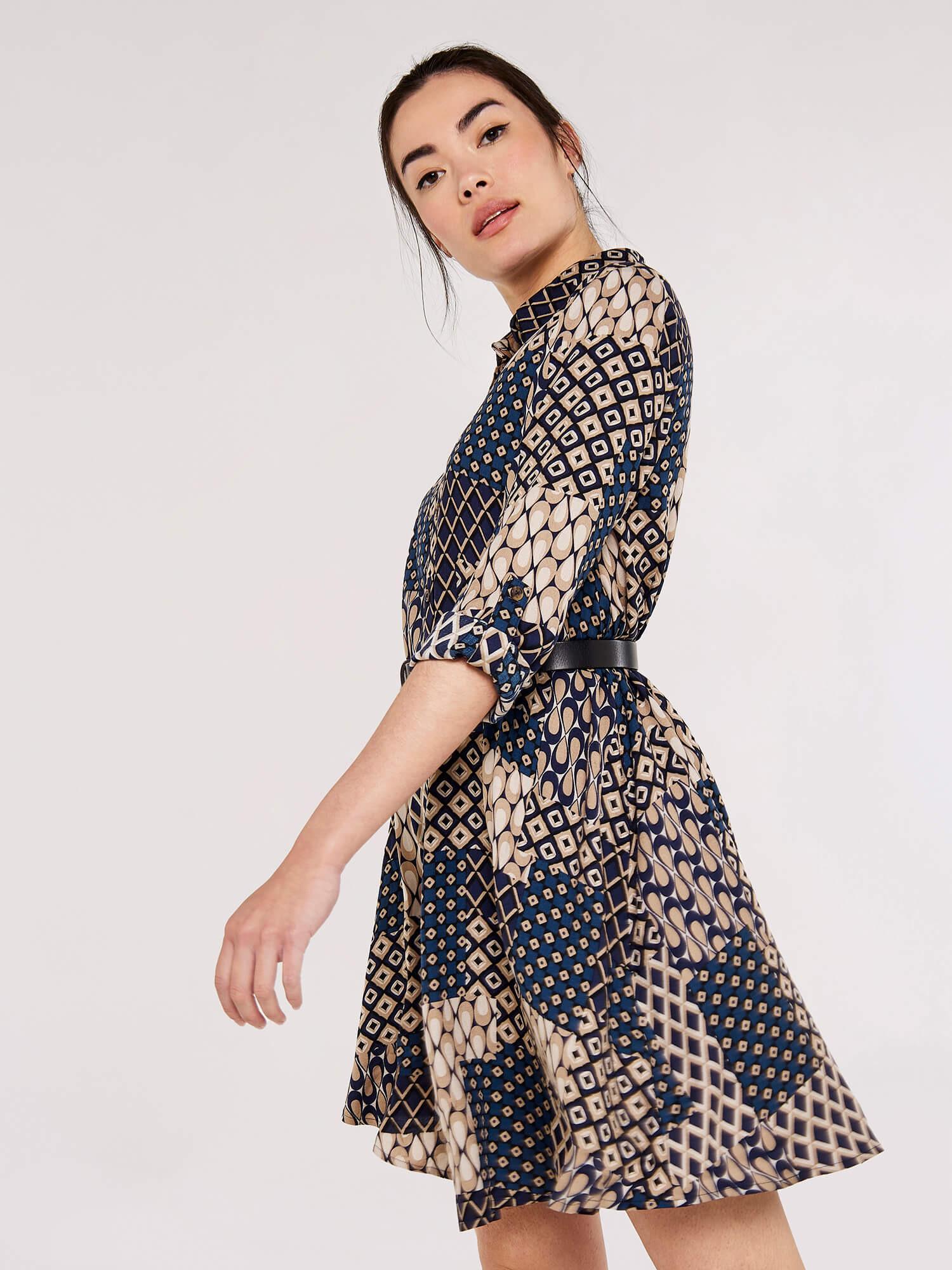 Make a statement with the Apricot Patchwork Swing Shirt Dress. This dress features an eye-catching patchwork pattern and a swing silhoue