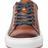 This cognac leather sneaker features a sleek design complemented by stylish white trim, making it a versatile addition to any wardrobe. Made from high-quality materials, it offers both durability and comfort, ideal for casual outings or everyday wear. The combination of classic black and crisp white ensures a modern aesthetic, while the sneaker's lightweight construction offers ease of movement. Perfect for those seeking a blend of fashion and functionality.