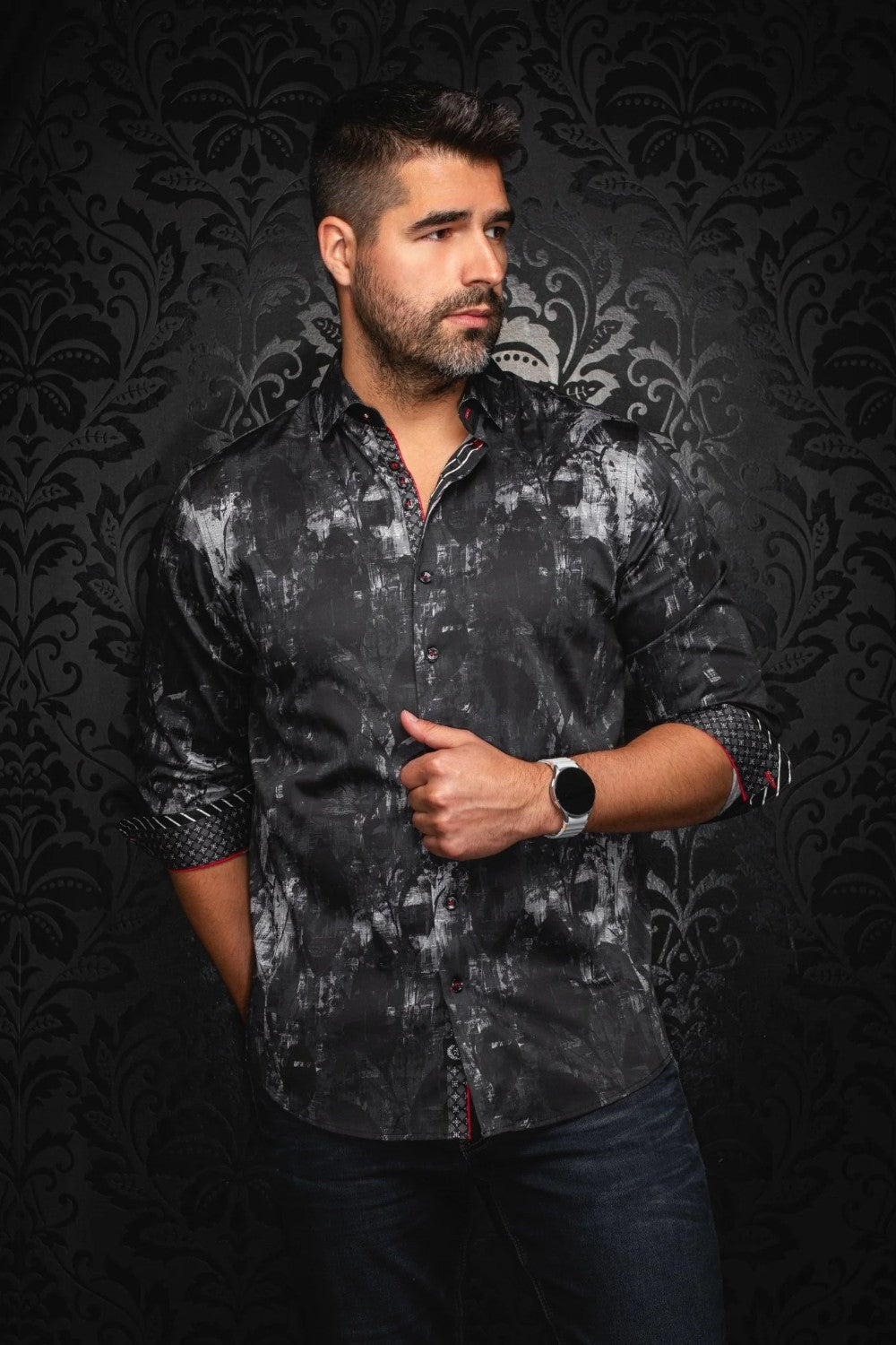 Man wearing a dark patterned shirt against a black textured background