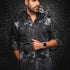 Man wearing a dark patterned shirt against a black textured background