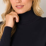 Woman wearing a black turtleneck sweater against a neutral background