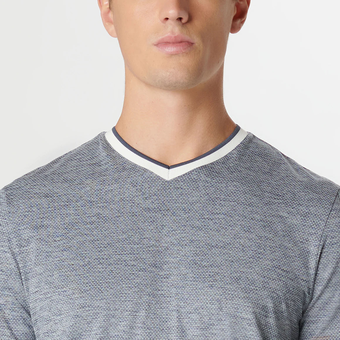 This performance short-sleeved V-neck shirt features a stylish speckled heather pattern with contrast neckline. Beyond style, this garment offers UV50 SPF protection, making it perfect for outdoor activities.