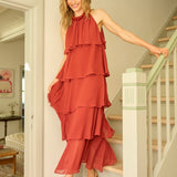 Woman in a red dress standing on a staircase in a home setting
