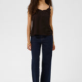 Woman wearing a brown top and dark blue jeans on a white background