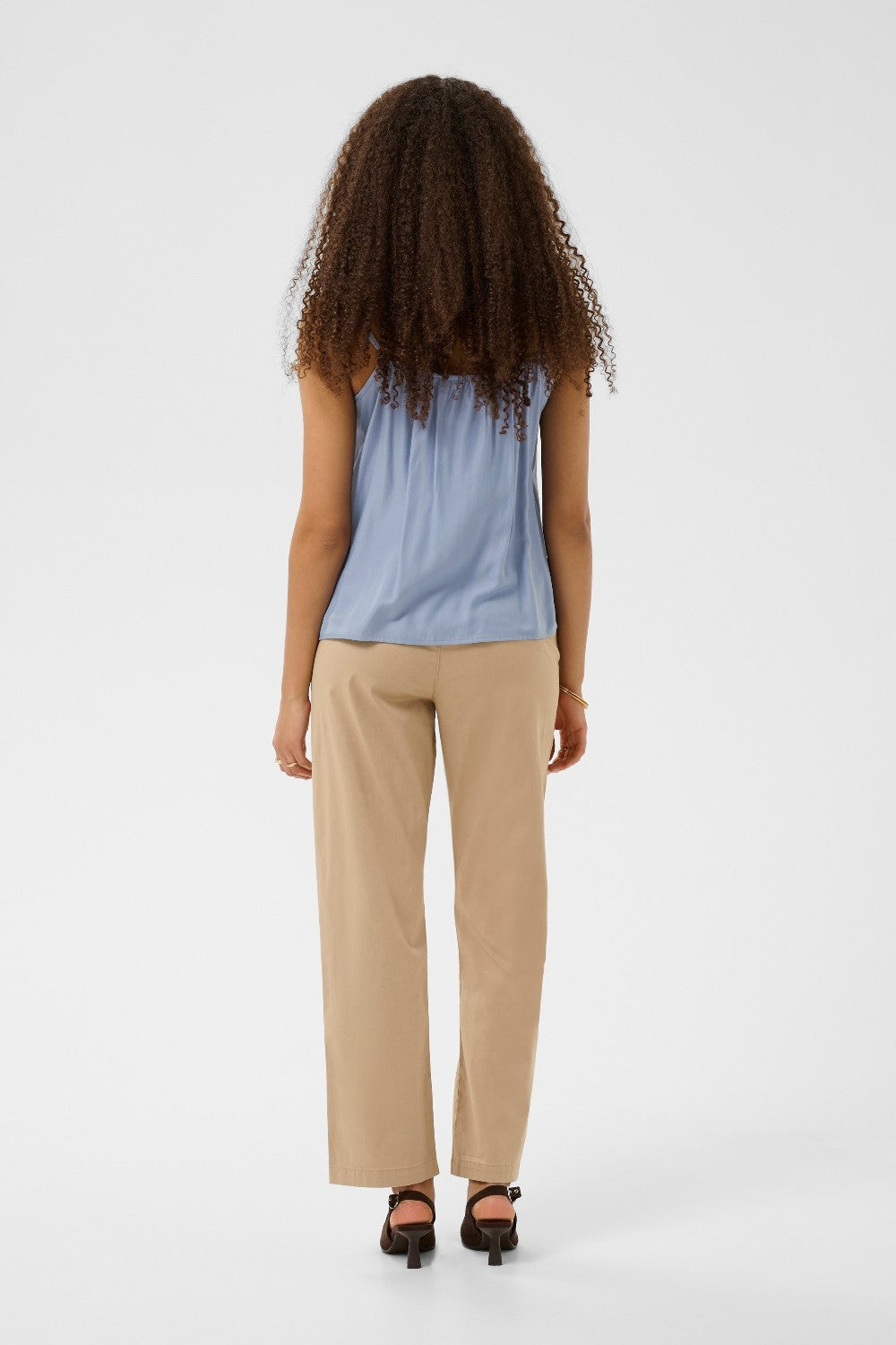 Woman wearing a light blue sleeveless top  on a white background