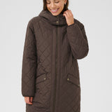 Woman wearing a brown quilted coat on a white background