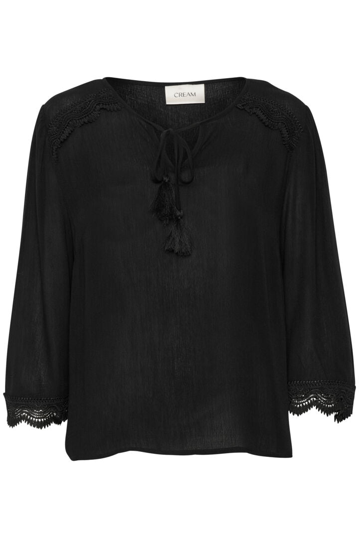 The Cream Bea 3/4 Sleeve Lace Blouse features a sleek black colour and a charming front tie with tassels. Elevate any outfit with this versatile piece, perfect for adding a touch of sophistication to your wardrobe.