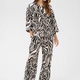 Woman wearing a zebra print outfit on a white background