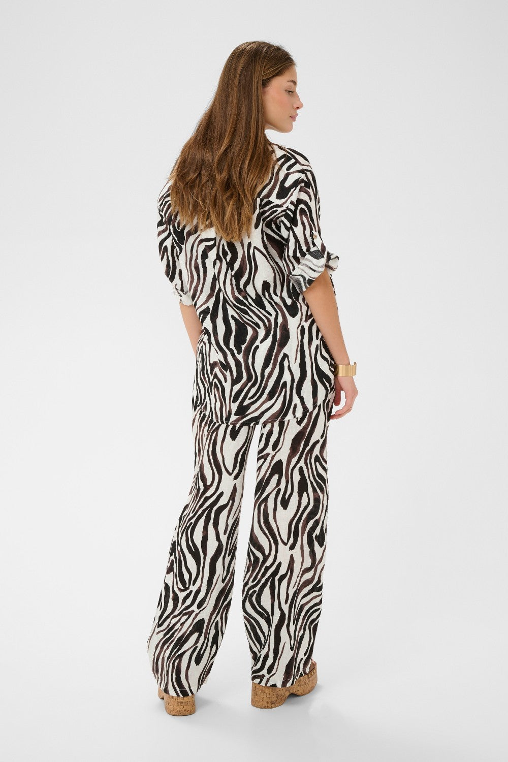 Woman wearing a zebra print outfit on a white background