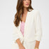 Woman wearing a white blazer over a pink top on a white background
