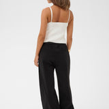 Woman wearing a white top and black pants on a white background