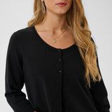 Woman wearing a black cardigan with a plain background