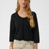 Woman wearing a black cardigan and patterned pants on a white background