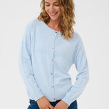 Woman wearing a light blue cardigan and dark blue jeans on a white background