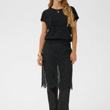 Woman wearing a black outfit with a lace skirt on a white background