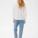 Person wearing a white shirt and light blue jeans on a white background
