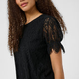 Woman wearing a black lace top against a white background