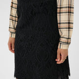 Black lace skirt worn with a plaid shirt on a white background