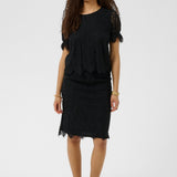 Woman wearing a black lace top and skirt on a white background