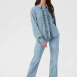 Woman wearing a light blue denim outfit on a white background