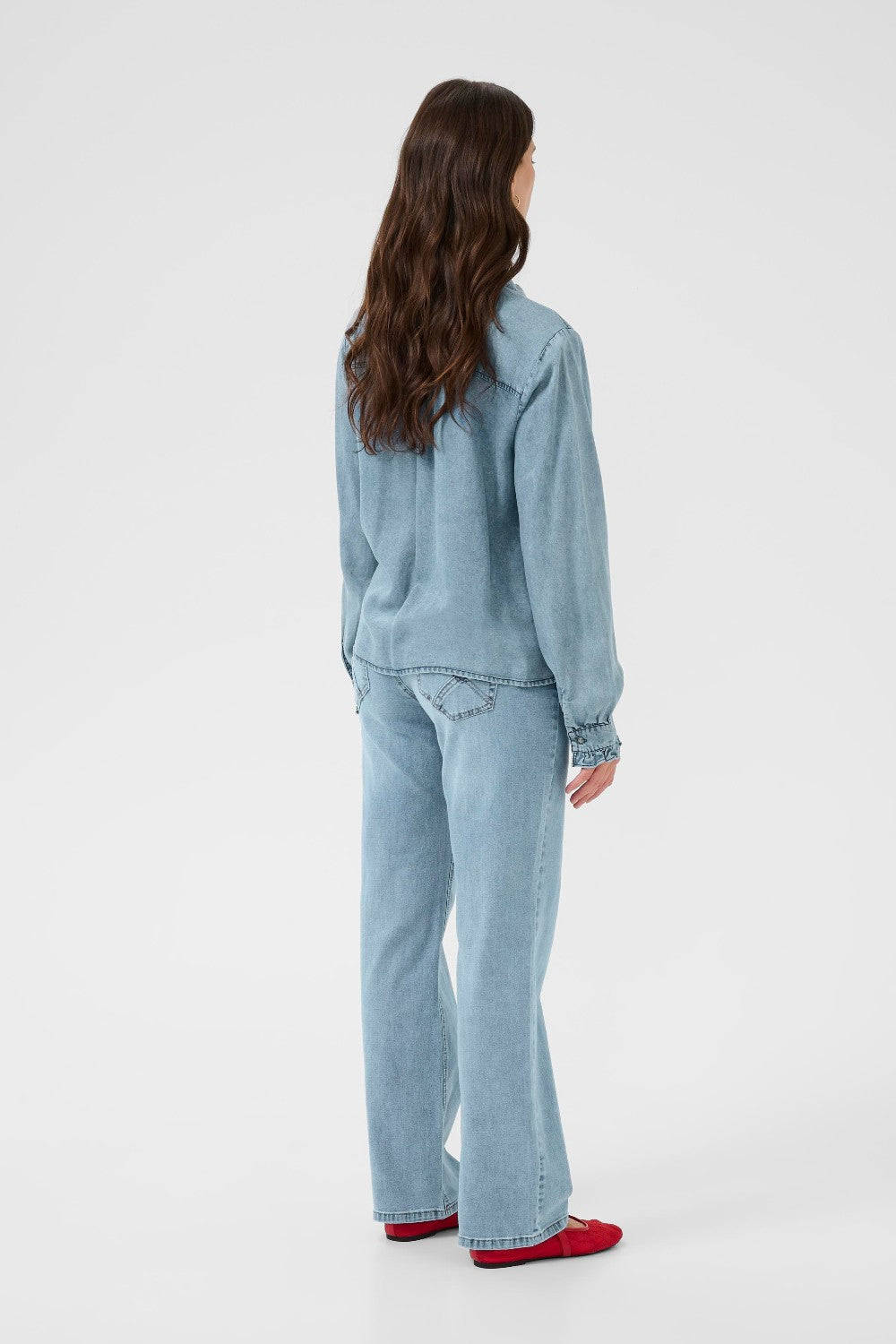 Person wearing a light blue outfit on a white background