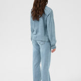 Person wearing a light blue outfit on a white background