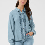Woman wearing a light blue denim shirt and jeans on a white background