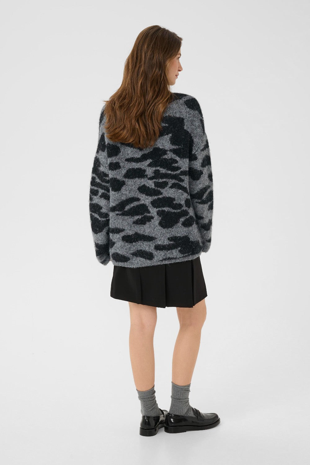 Person wearing a camouflage sweater on a white background