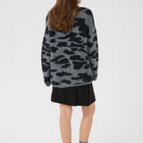Person wearing a camouflage sweater on a white background
