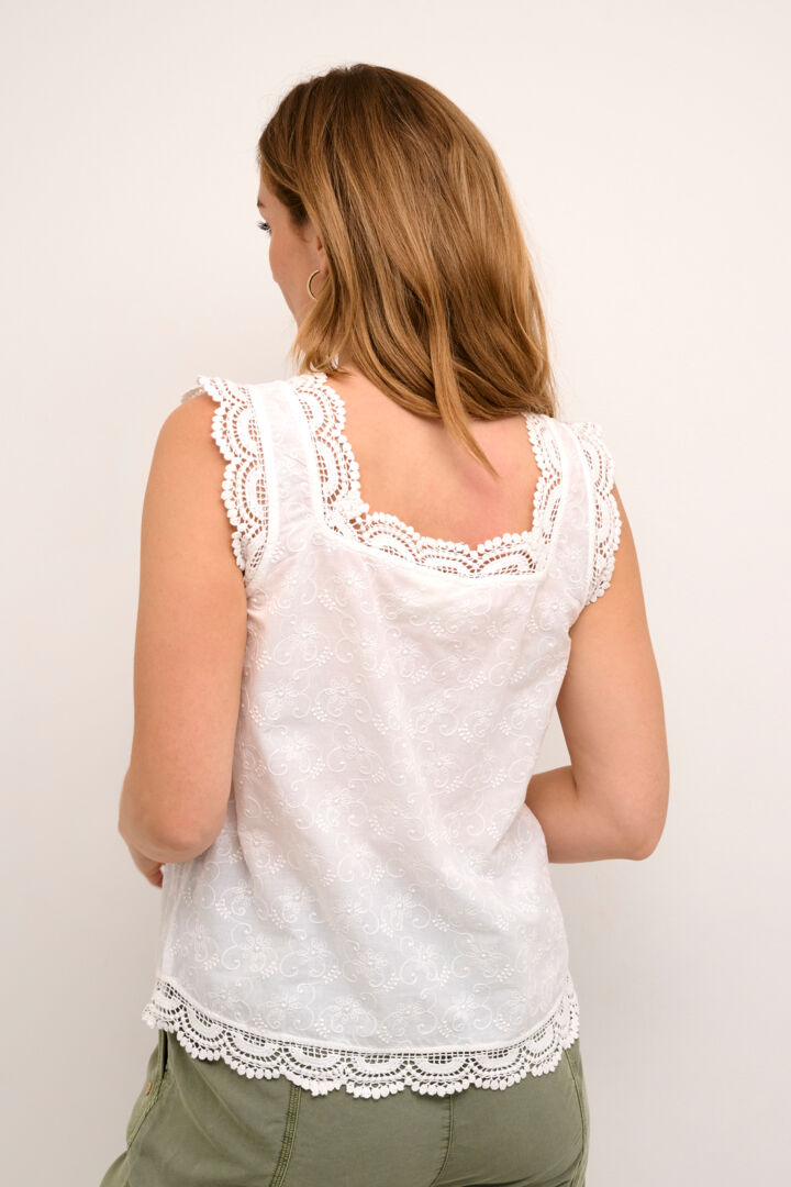 The Cream Emma Top is a romantic and stylish addition to any wardrobe. Made with 100% cotton, it features a sleeveless design and a flattering square neckline. The delicate embroidery and lace add a touch of elegance to this versatile piece.