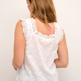 The Cream Emma Top is a romantic and stylish addition to any wardrobe. Made with 100% cotton, it features a sleeveless design and a flattering square neckline. The delicate embroidery and lace add a touch of elegance to this versatile piece.