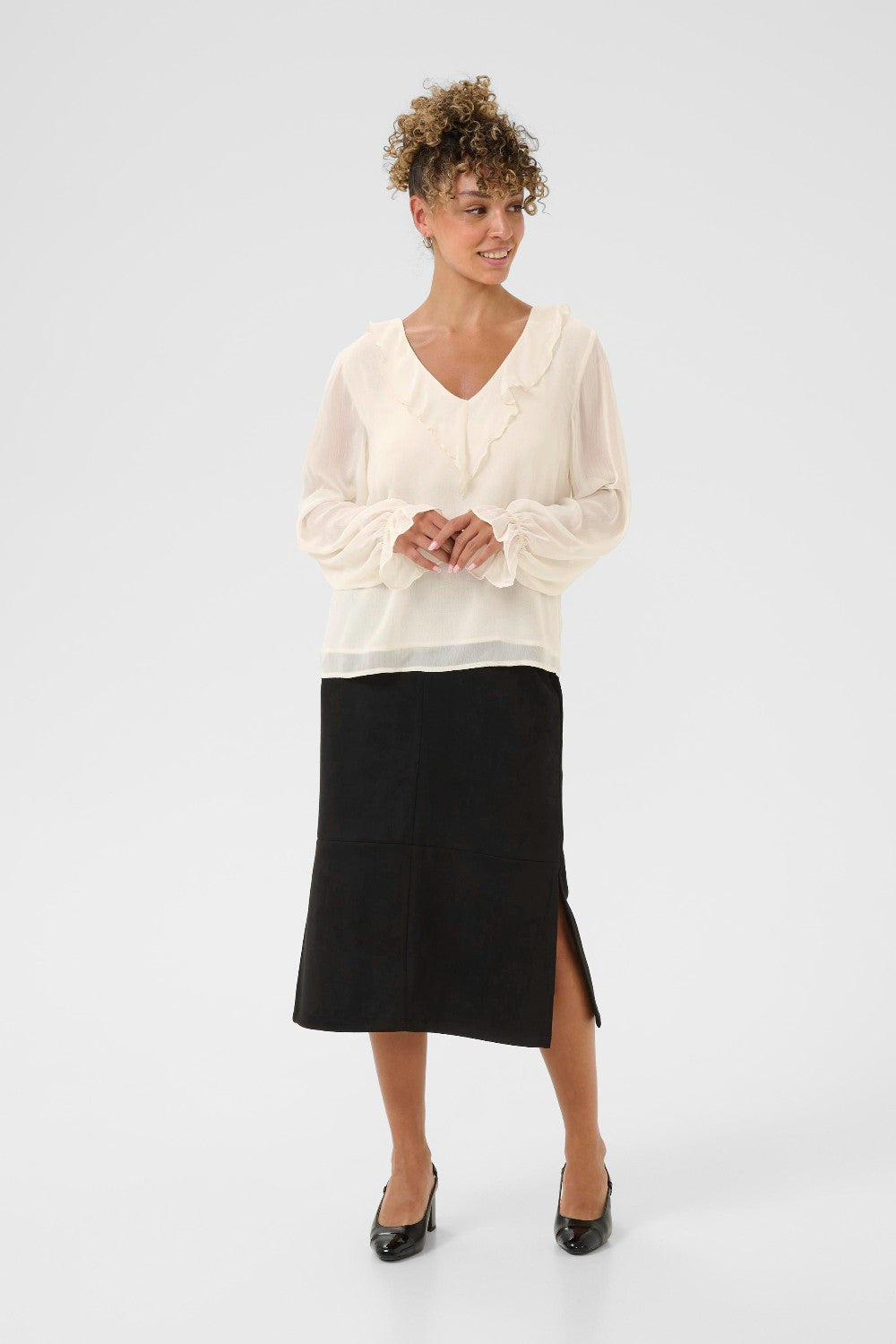 Woman wearing a white blouse and black skirt on a white background