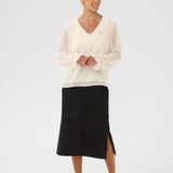 Woman wearing a white blouse and black skirt on a white background