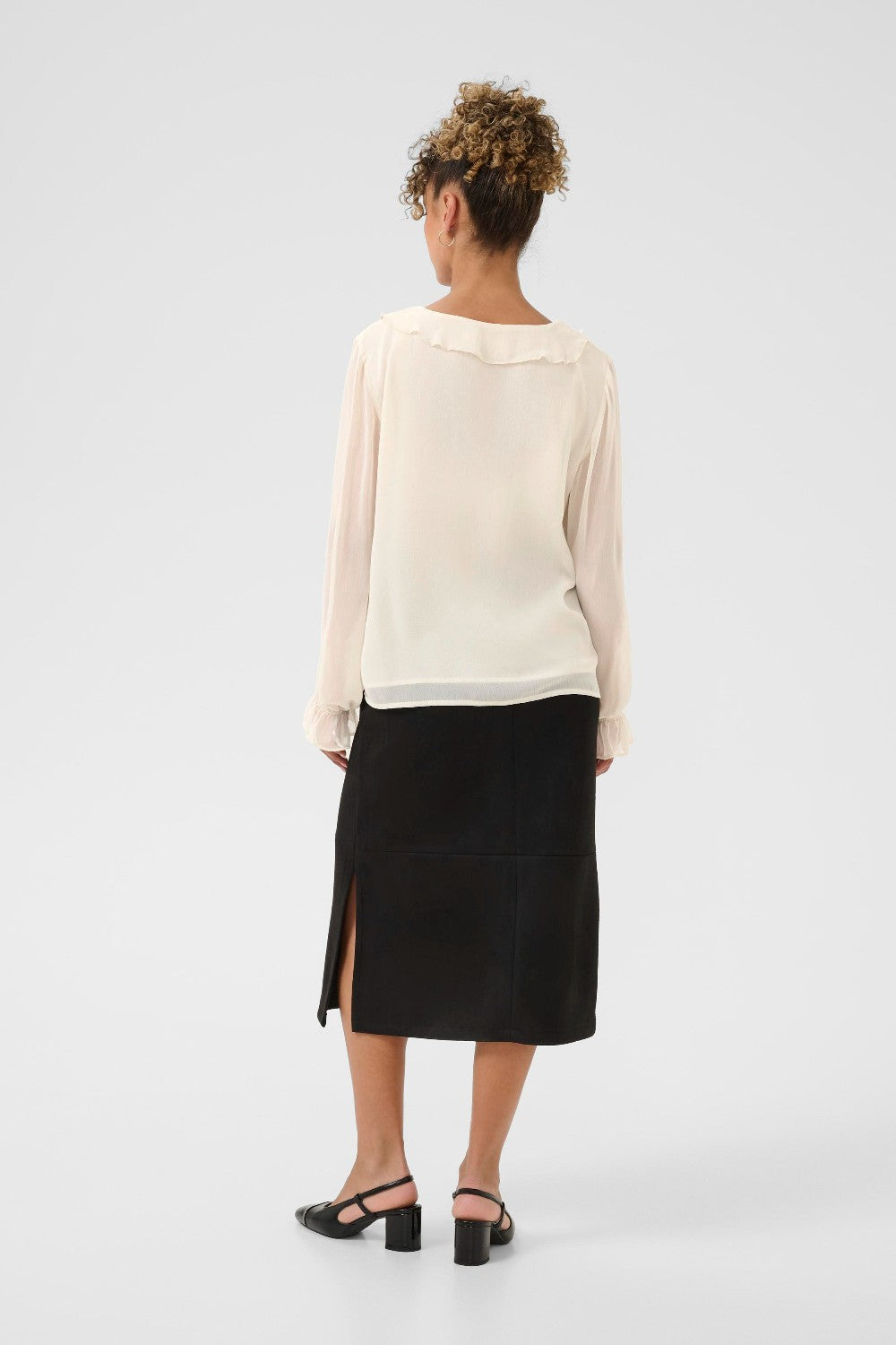 Person wearing a white top and black skirt on a white background