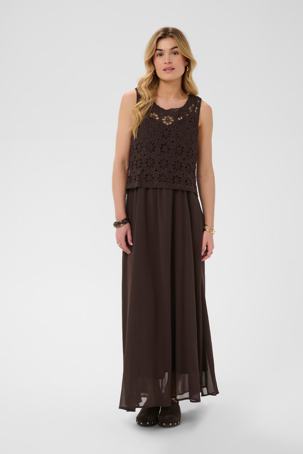 Woman wearing a brown dress with a crochet top on a white background